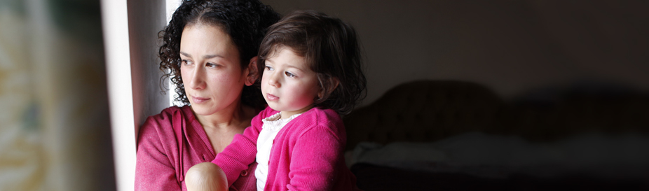A women holding her child looking out of a window